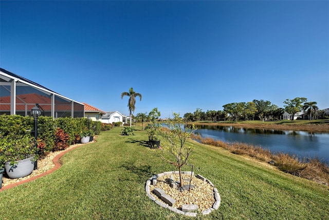 view of yard featuring a lanai and a water view