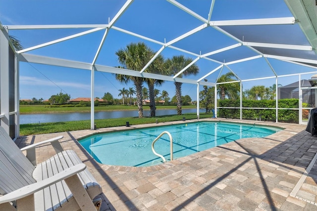 view of pool featuring glass enclosure, a patio area, and a water view