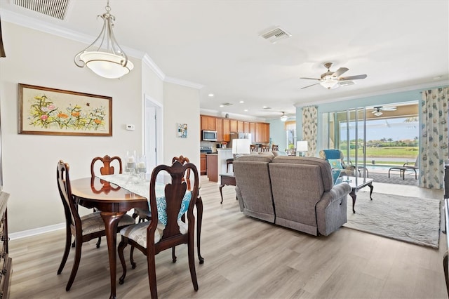 dining room with light hardwood / wood-style floors, ceiling fan, and crown molding