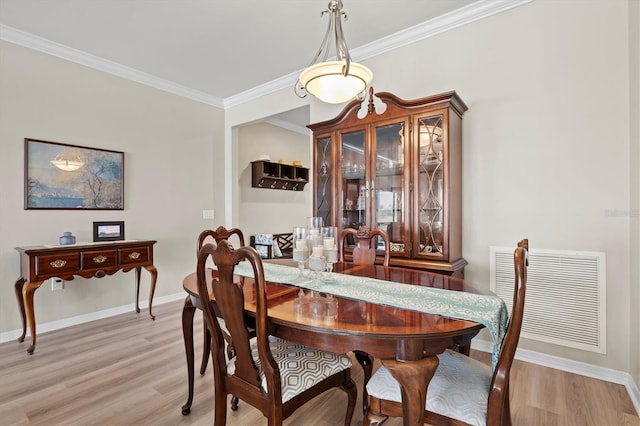 dining space featuring light hardwood / wood-style floors and crown molding