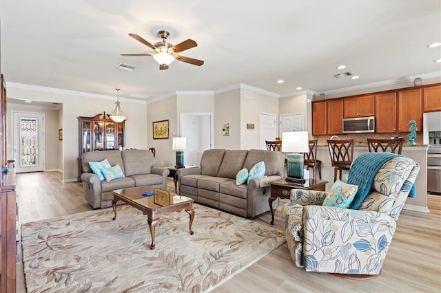 living room featuring crown molding, ceiling fan, and light hardwood / wood-style floors