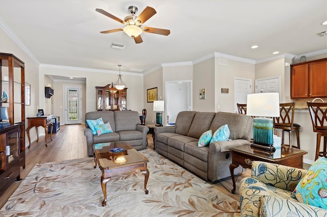 living room featuring crown molding, light hardwood / wood-style flooring, and ceiling fan