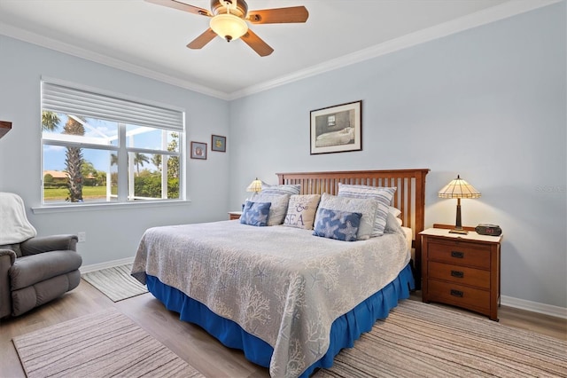 bedroom featuring light hardwood / wood-style floors, ceiling fan, and ornamental molding