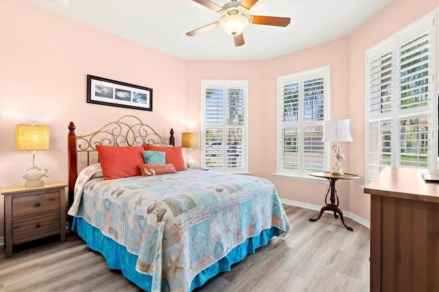 bedroom with multiple windows, ceiling fan, and light hardwood / wood-style flooring