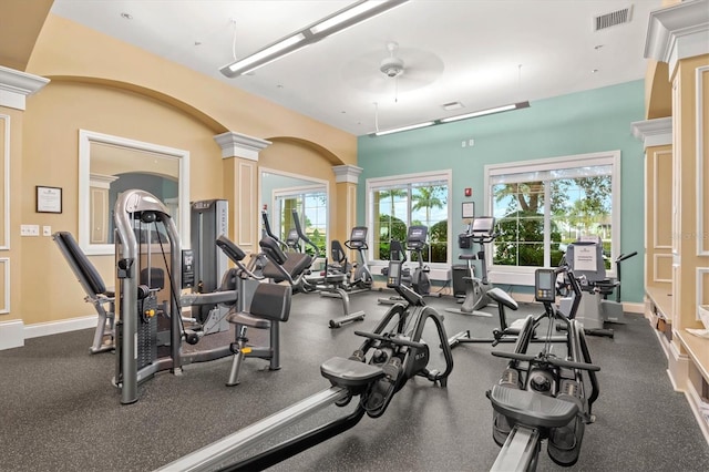 workout area with decorative columns and ceiling fan