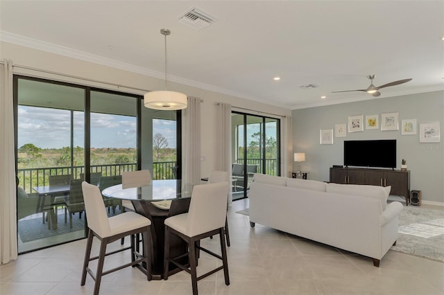 dining room with ceiling fan, ornamental molding, and light tile patterned floors