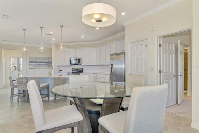 dining space with sink and crown molding