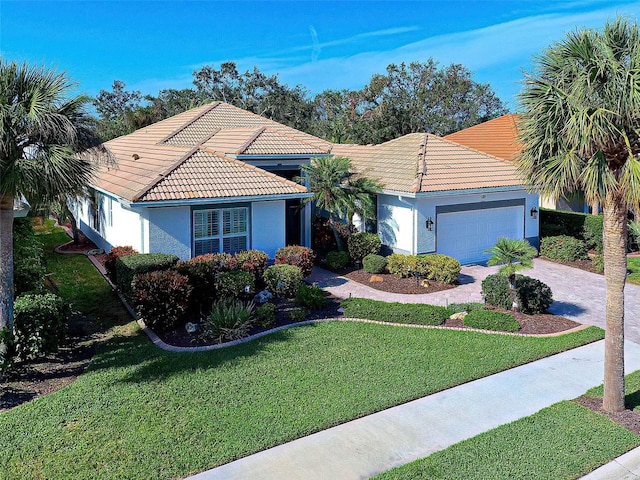 mediterranean / spanish-style house featuring a garage and a front lawn