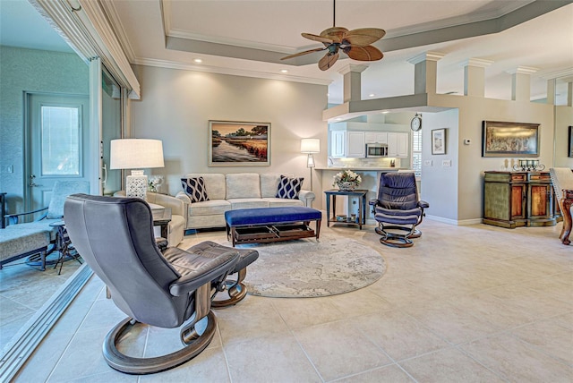 living room with a tray ceiling, ceiling fan, crown molding, and light tile patterned floors