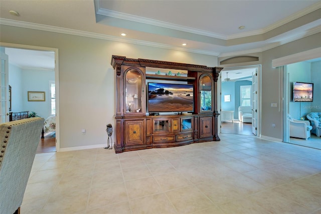 tiled living room with a tray ceiling, ceiling fan, and ornamental molding