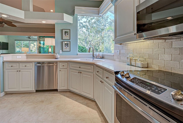 kitchen featuring a wealth of natural light, white cabinetry, sink, and appliances with stainless steel finishes