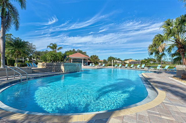 view of swimming pool featuring pool water feature and a patio