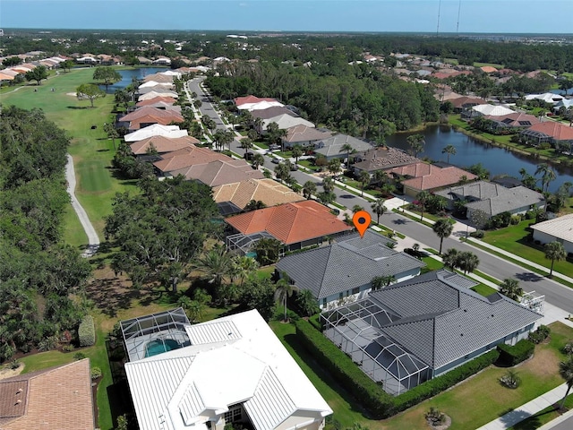 drone / aerial view featuring view of golf course, a water view, and a residential view