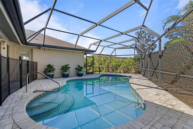 view of pool featuring glass enclosure and a patio