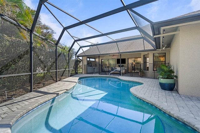 view of swimming pool featuring a lanai, a patio area, and ceiling fan