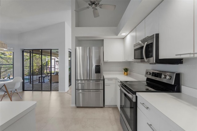 kitchen with appliances with stainless steel finishes, light tile patterned floors, white cabinetry, and ceiling fan