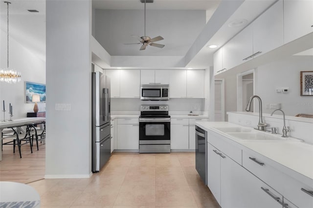 kitchen featuring white cabinets, decorative light fixtures, sink, and appliances with stainless steel finishes