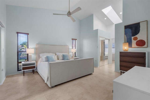 bedroom featuring a skylight, high vaulted ceiling, ceiling fan, and ensuite bathroom