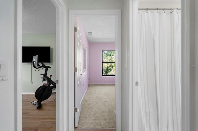 corridor with carpet flooring and a textured ceiling