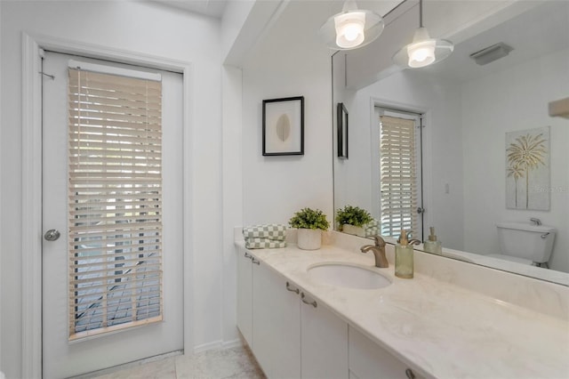 bathroom with tile patterned flooring, vanity, and toilet