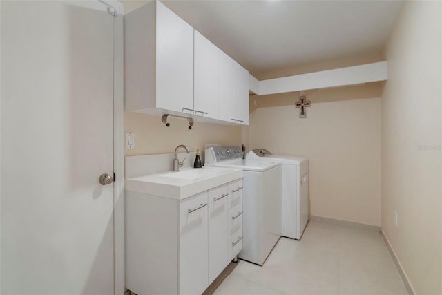 washroom with cabinets, separate washer and dryer, and sink