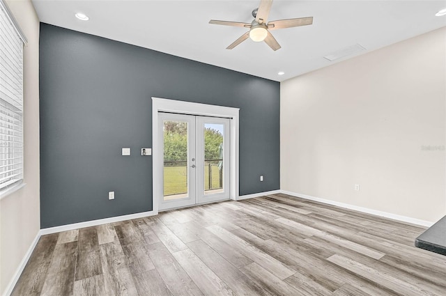 unfurnished room with ceiling fan, french doors, and light wood-type flooring