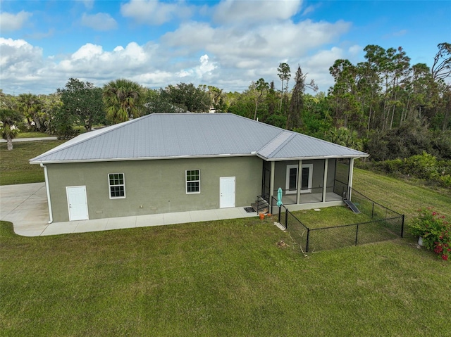 rear view of property featuring a yard and a sunroom