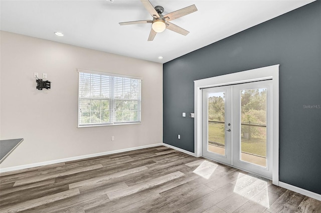 spare room with hardwood / wood-style floors, ceiling fan, a wealth of natural light, and french doors