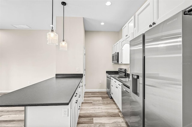 kitchen featuring hanging light fixtures, light hardwood / wood-style flooring, stainless steel appliances, and white cabinetry