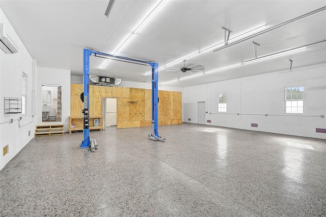 garage with an AC wall unit and ceiling fan