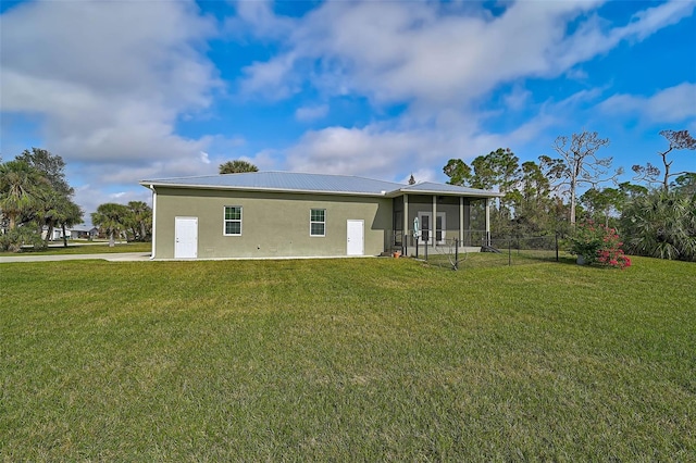 back of property featuring a yard and a sunroom