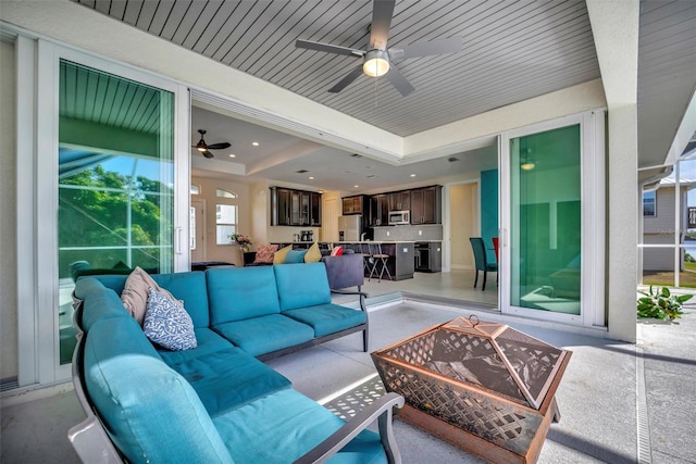 living room featuring ceiling fan and a tray ceiling