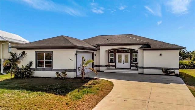 property entrance featuring a garage, a yard, and french doors