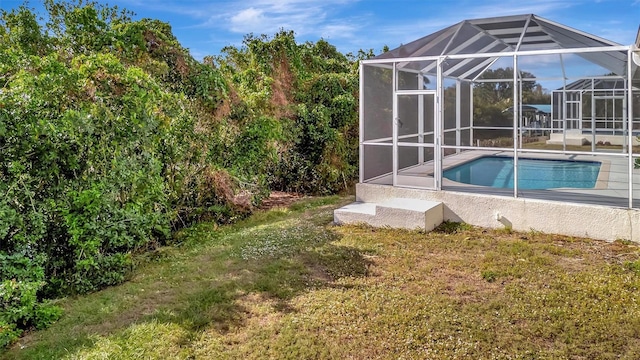 view of pool with glass enclosure and a lawn