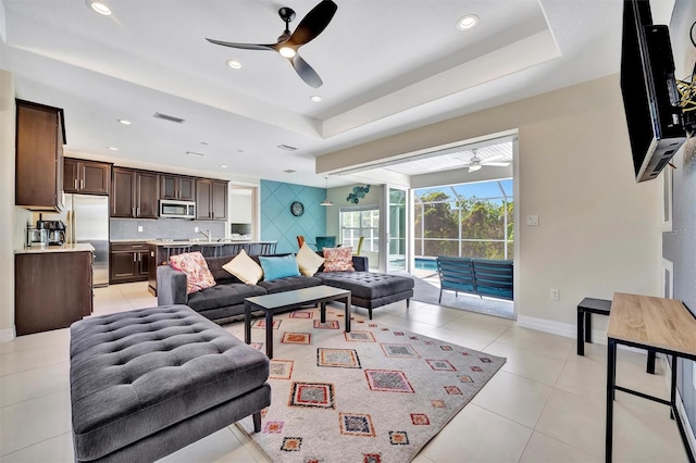 tiled living room with a raised ceiling and sink