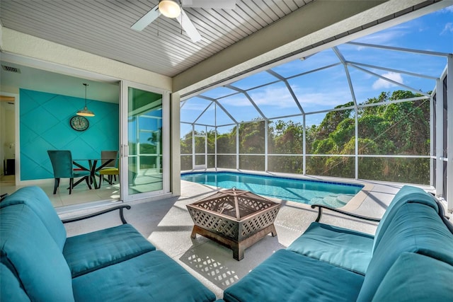 view of swimming pool featuring ceiling fan, a patio area, and glass enclosure