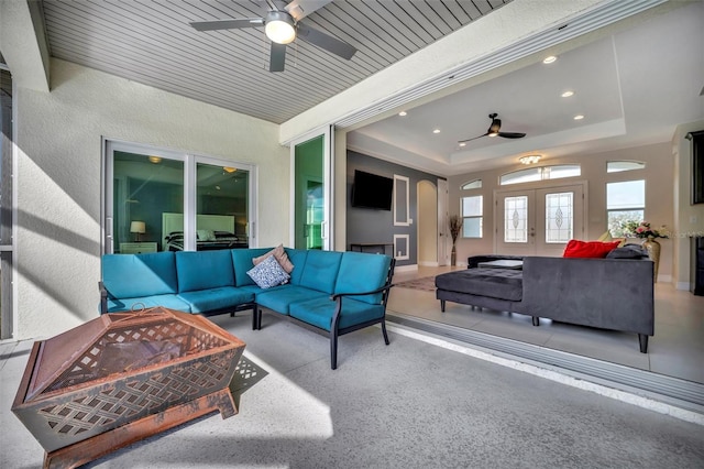 exterior space with ceiling fan, a raised ceiling, and wooden ceiling