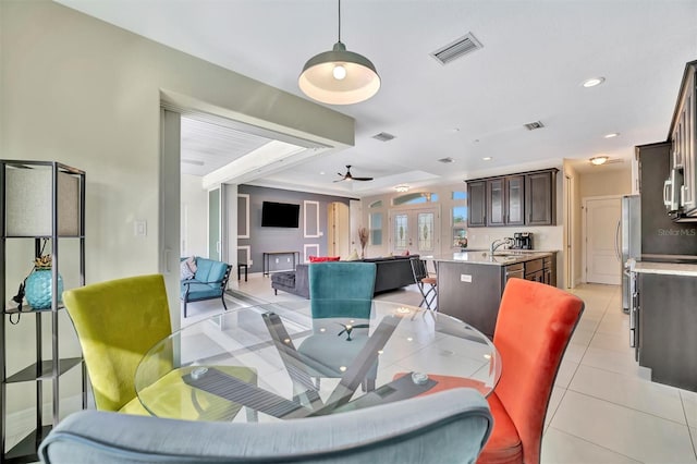 dining space with ceiling fan, light tile patterned floors, and sink