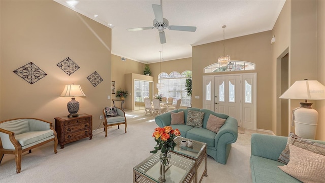 living room with a towering ceiling, light colored carpet, ceiling fan, and ornamental molding