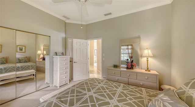 bedroom with ornamental molding, light colored carpet, ceiling fan, a high ceiling, and a closet