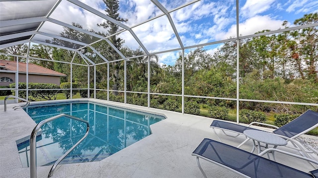 view of pool with glass enclosure and a patio area