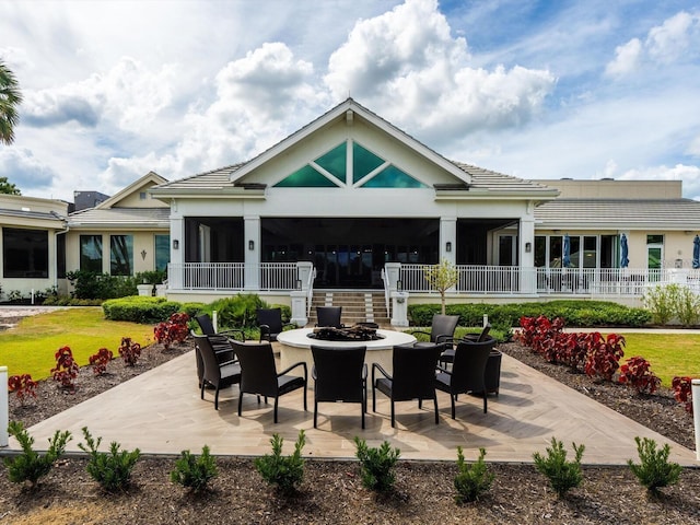 rear view of property with a patio and an outdoor fire pit