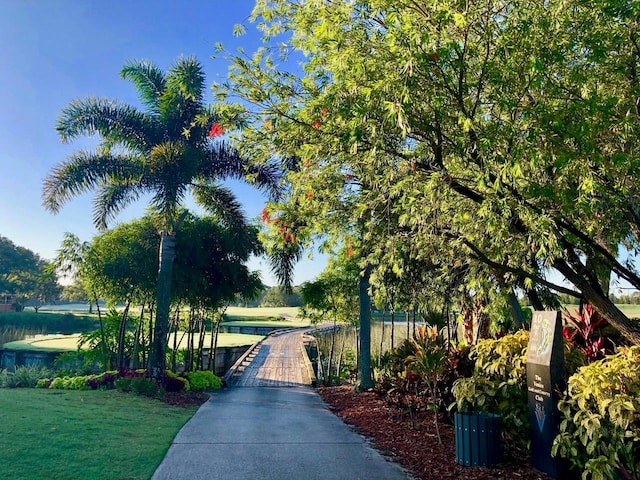 view of home's community with a water view and a yard