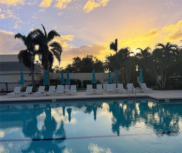 pool at dusk with a patio