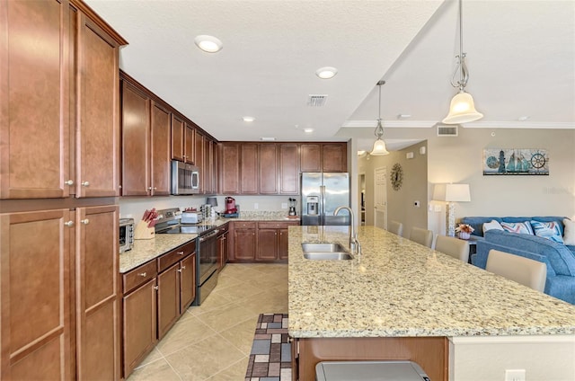 kitchen with sink, stainless steel appliances, a kitchen breakfast bar, a center island with sink, and ornamental molding