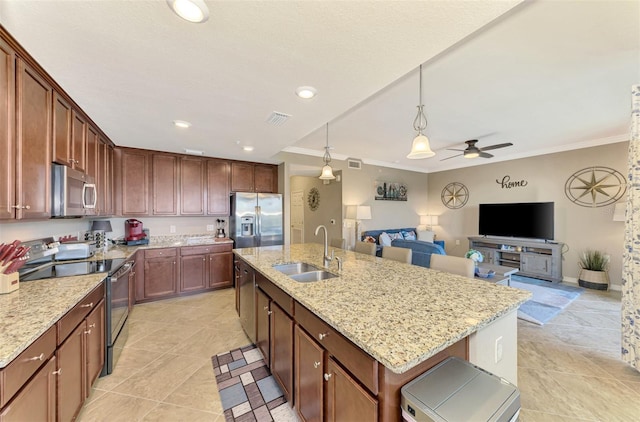 kitchen with stainless steel appliances, ceiling fan, crown molding, sink, and an island with sink