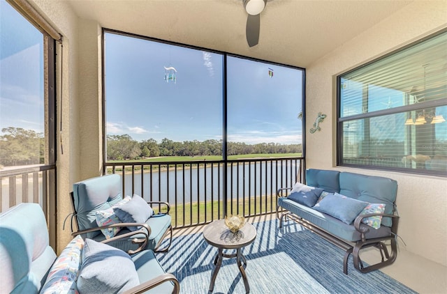 sunroom with ceiling fan, a water view, and plenty of natural light