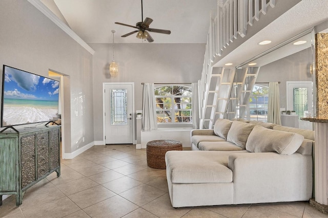 living room featuring a high ceiling, ceiling fan, and light tile patterned floors