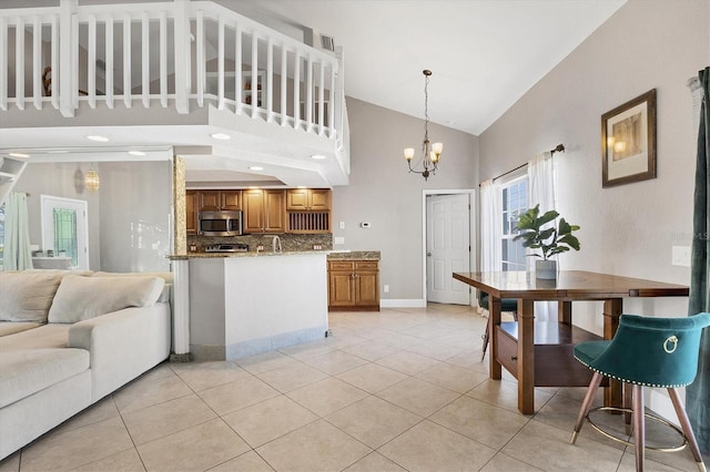 kitchen with high vaulted ceiling, light tile patterned floors, and light stone countertops