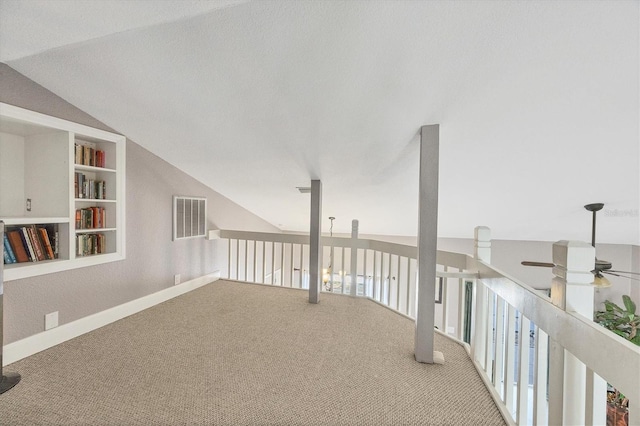 interior space featuring lofted ceiling, ceiling fan, carpet, and built in features